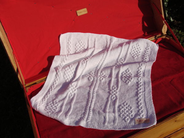 Couverture bébé 100% coton présentée sur une malle ancienne. Création originale : La malle au Coton -W2