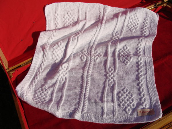 Couverture bébé 100% coton présentée sur une malle ancienne. Création originale : La malle au Coton -W3