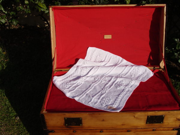 Couverture bébé 100% coton présentée sur une malle ancienne. Création originale : La malle au Coton -W6