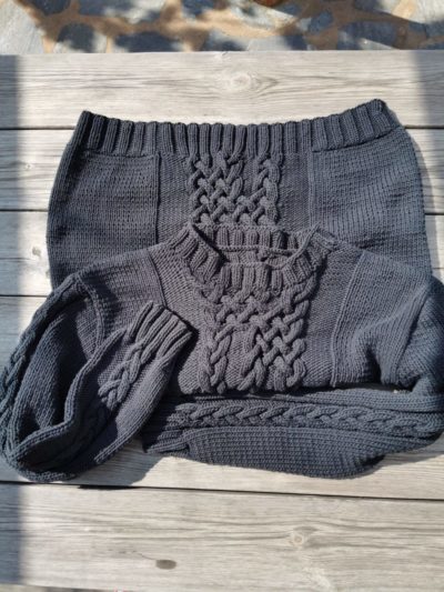 Joli pull noir en coton tricoté main présenté plié en deux